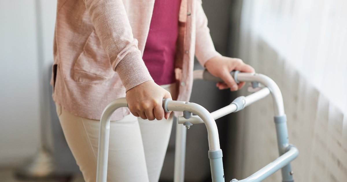 Person walking at home with a walking frame during recovery